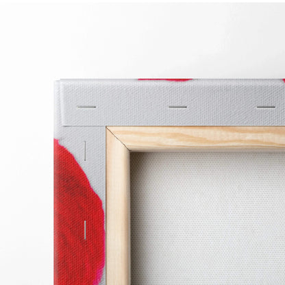 Close-up of stretched canvas wrapped around a wooden frame with red and white color details on the fabric edge.