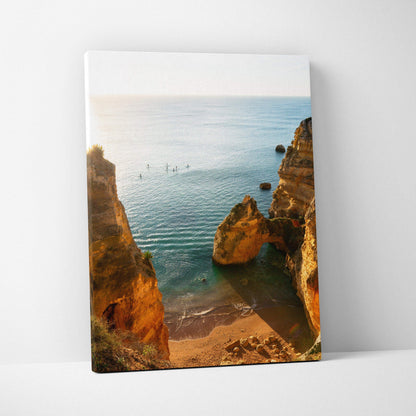 Canvas wall art featuring a serene beach scene with golden rock formations and calm blue ocean waters.