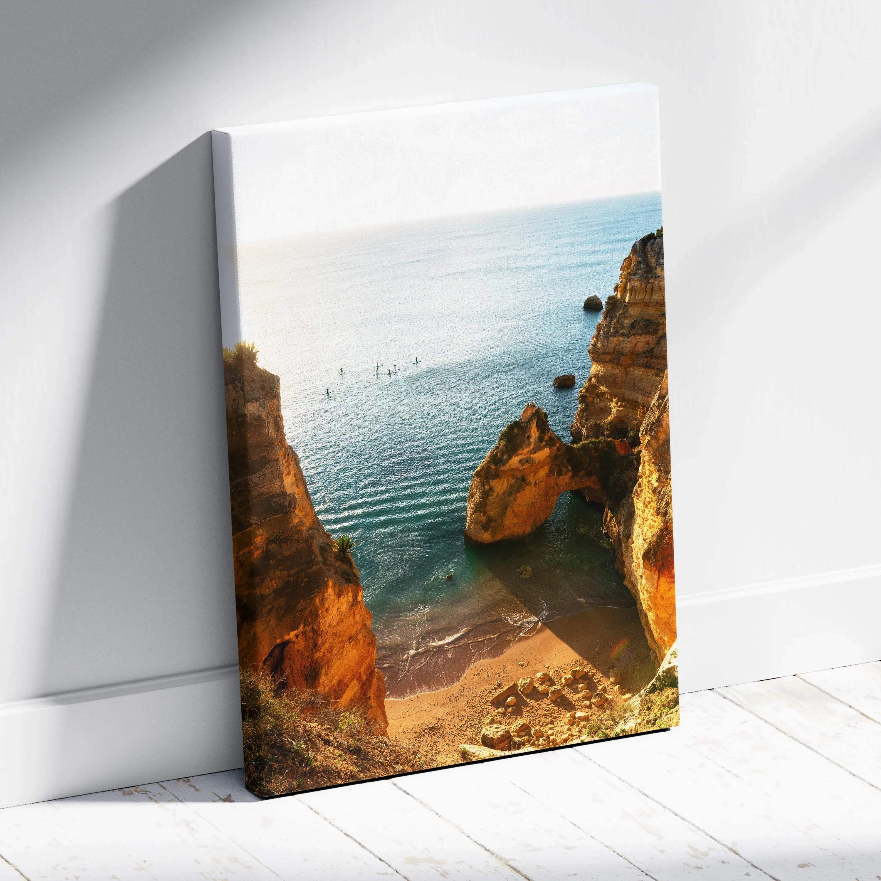 Canvas wall art depicting a serene beach scene with golden cliffs and calm blue water.