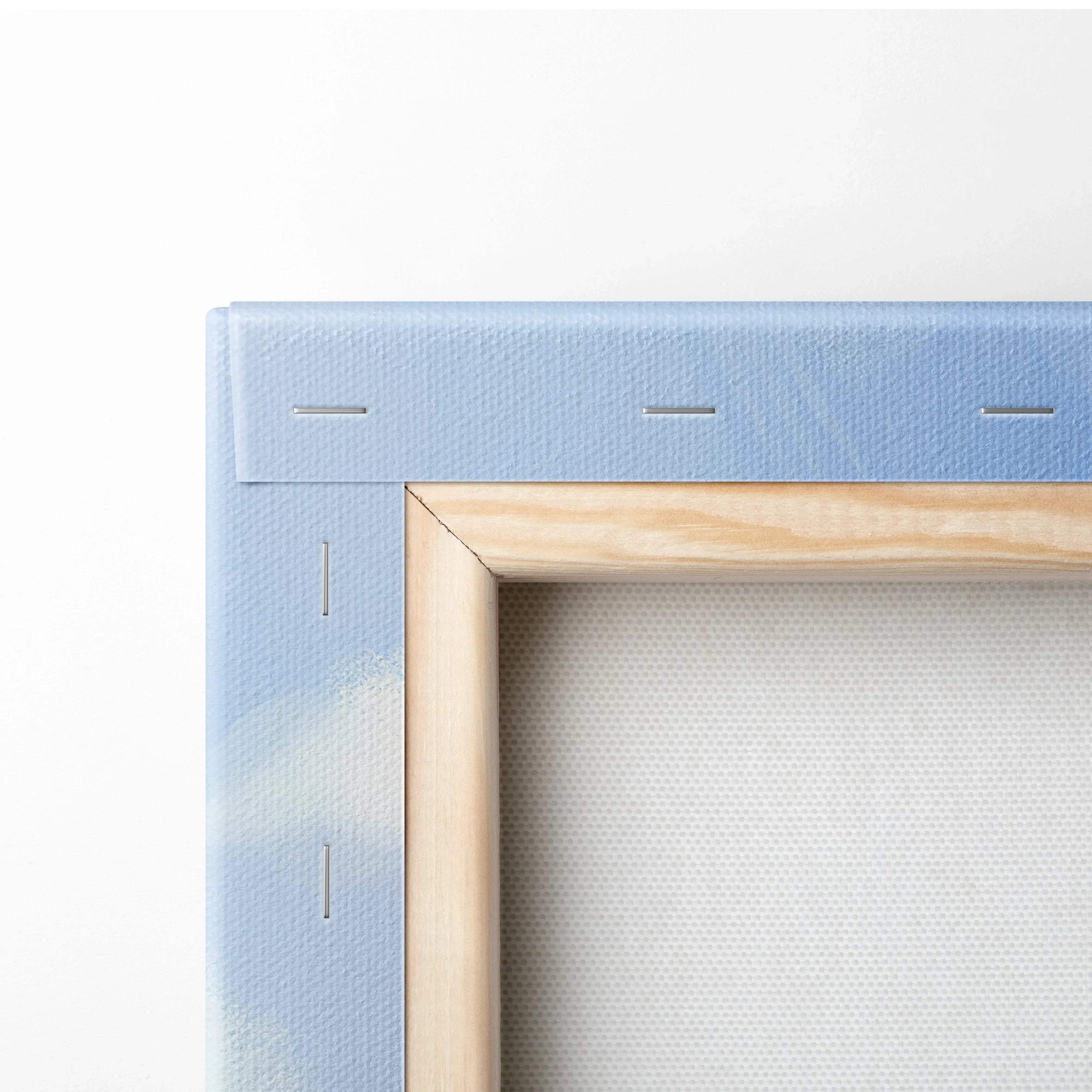 Close-up of wooden frame corner with light blue floral canvas stretched and stapled for wall art decor.