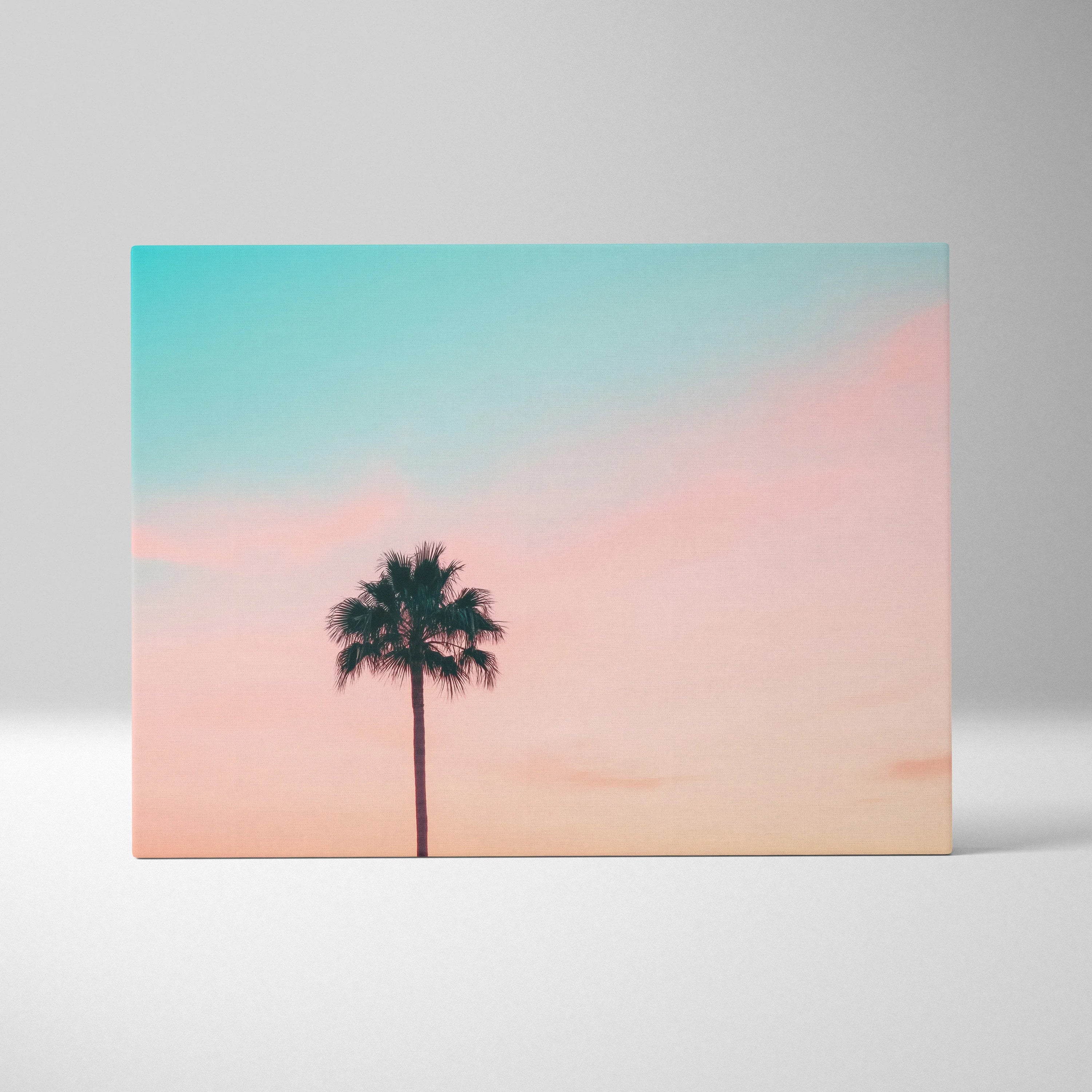 Minimalist canvas wall art featuring a black palm tree silhouette against a pastel sunset sky for modern decor.
