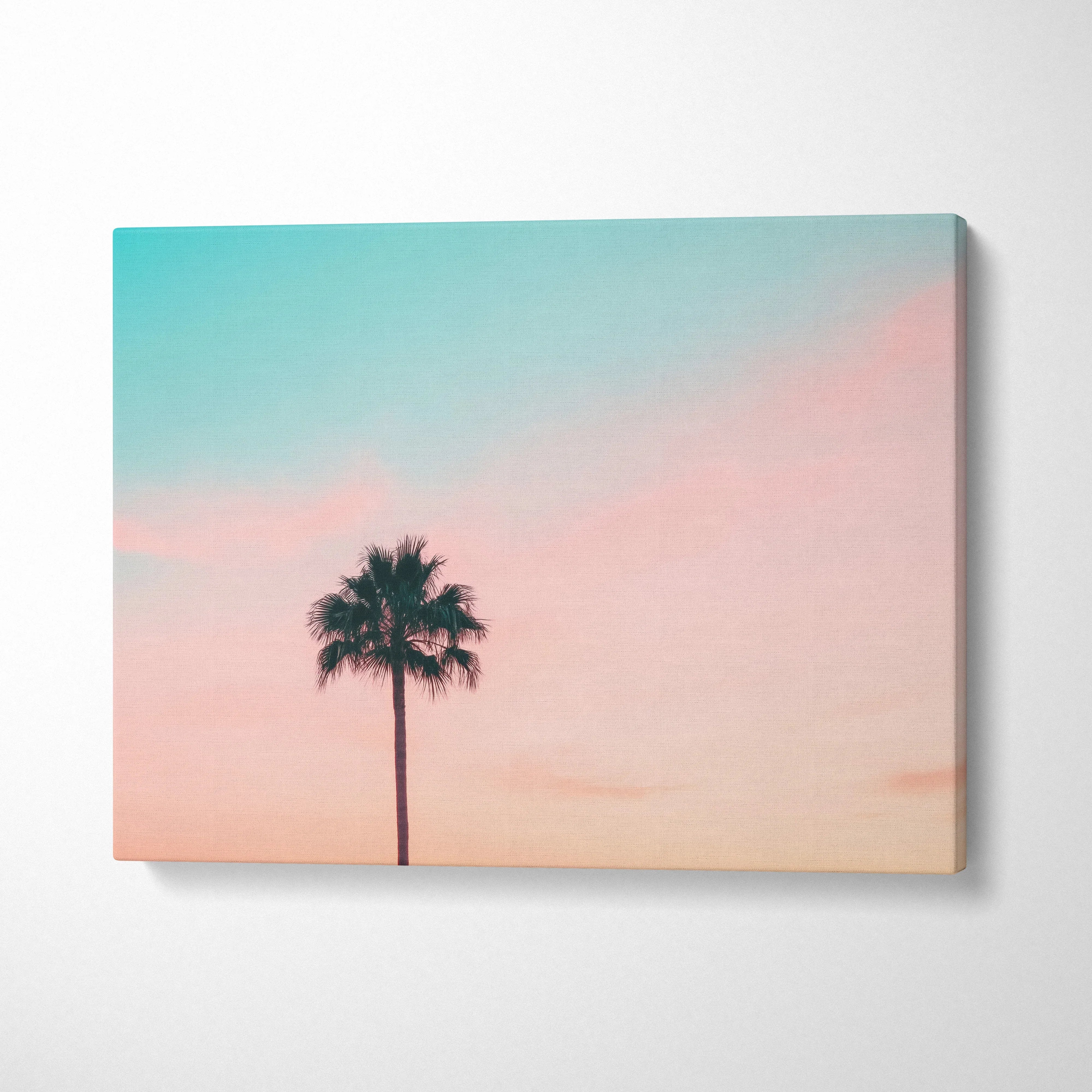Minimalist canvas wall art featuring a lone palm tree silhouette against a soft blue and pink sunset sky decor.
