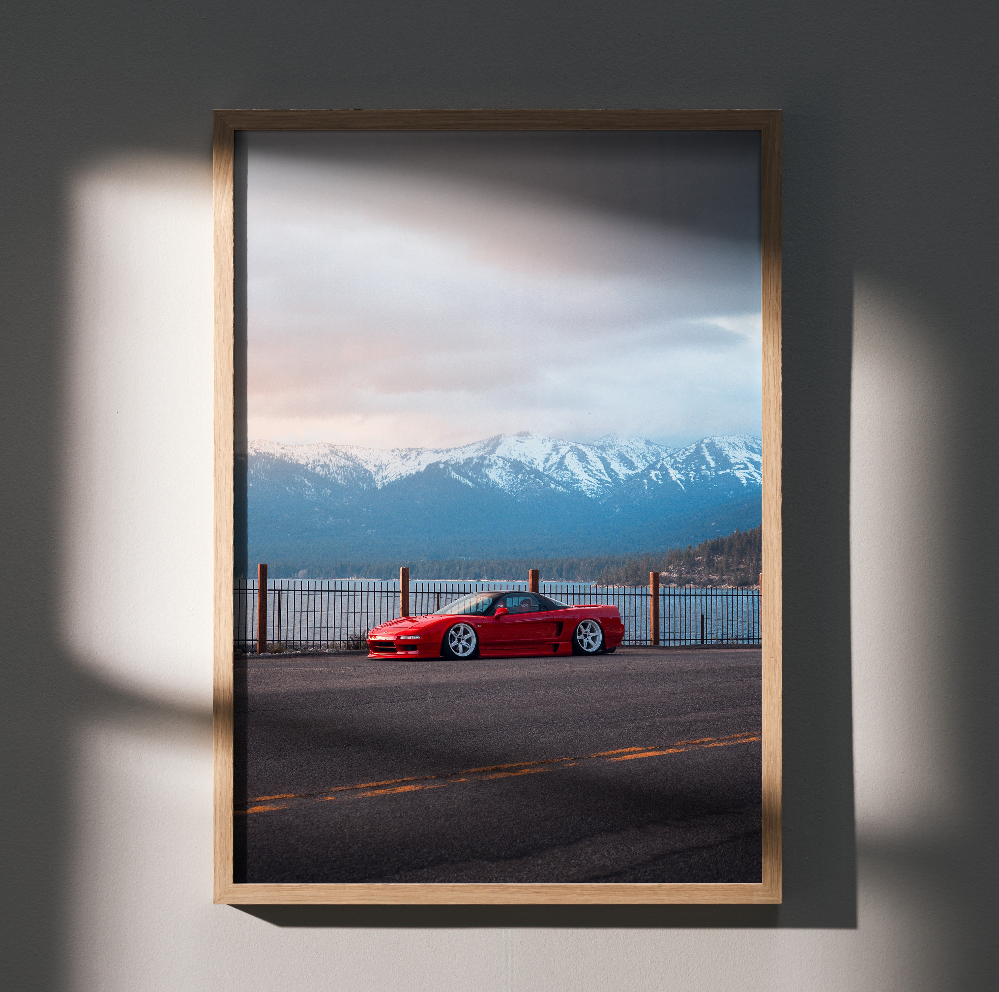 Acura NSX in red parked by waterfront with snowy mountains and cloudy sky poster wall art.