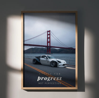 Motivational poster wall art with white Nissan 350Z on road and Golden Gate Bridge in background.