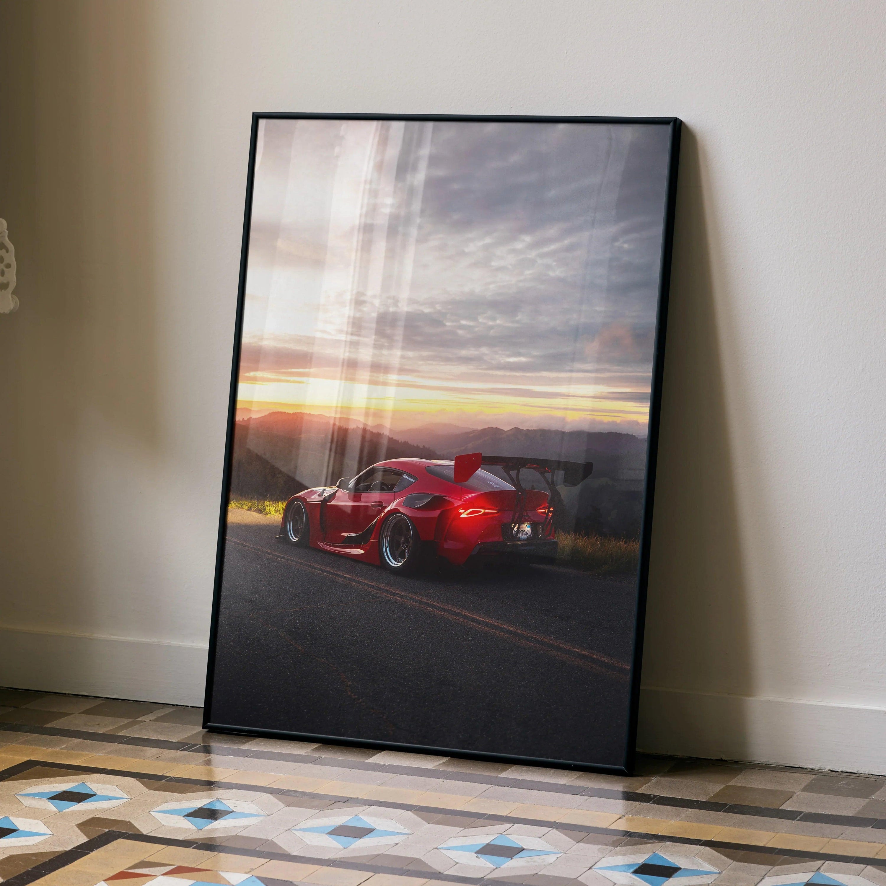 Toyota Supra Mk5 in red on sunset road, sleek JDM car poster wall art in black frame.