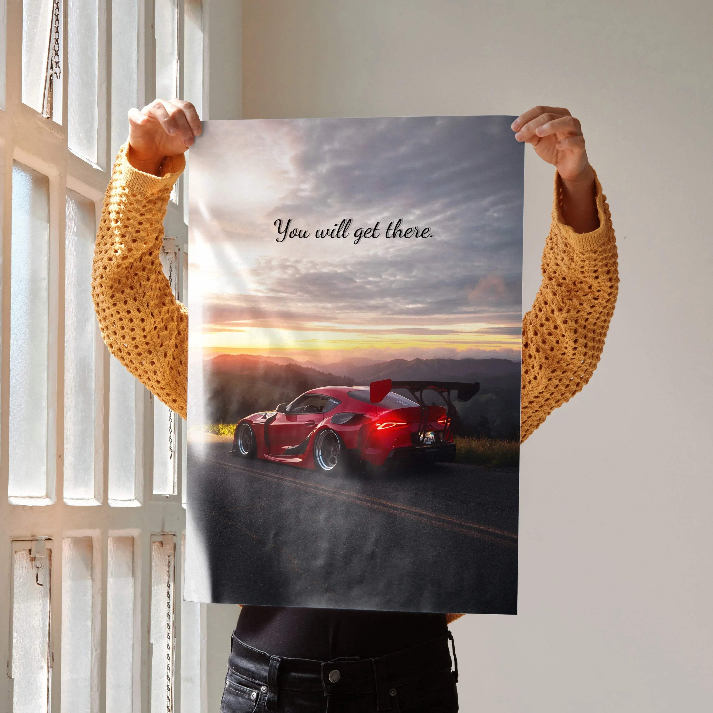 Motivational poster wall art featuring red Toyota Supra Mk5 with inspiring sunset background and text "You will get there".