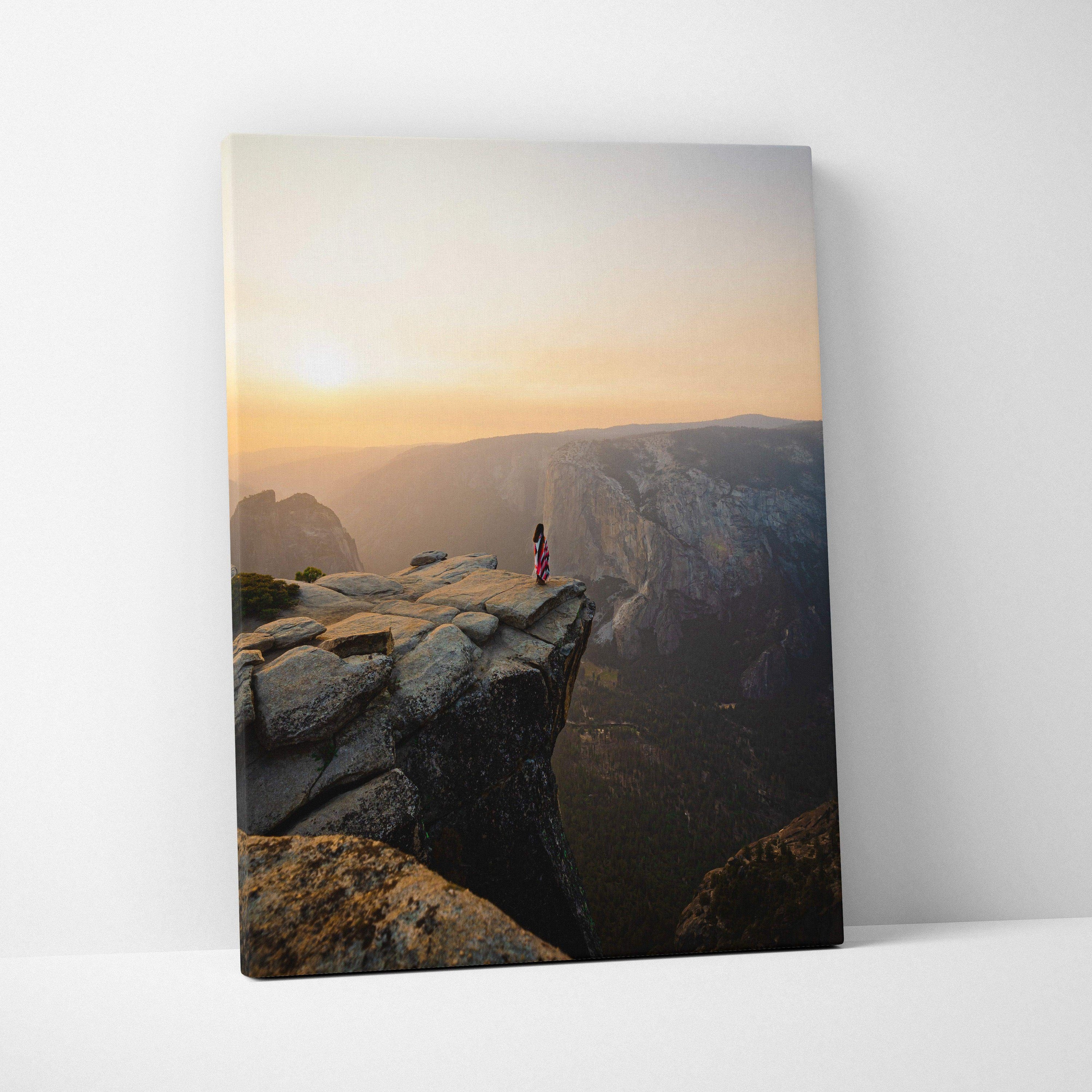 Visionary solitary figure on granite cliff at sunrise over canyon canvas art