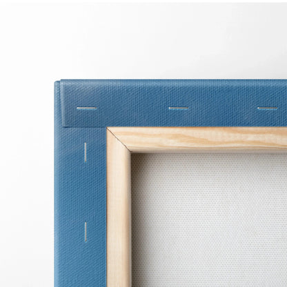 Close-up of blue wrapped canvas with wooden stretcher bars and metal staples, showcasing high-quality canvas art.