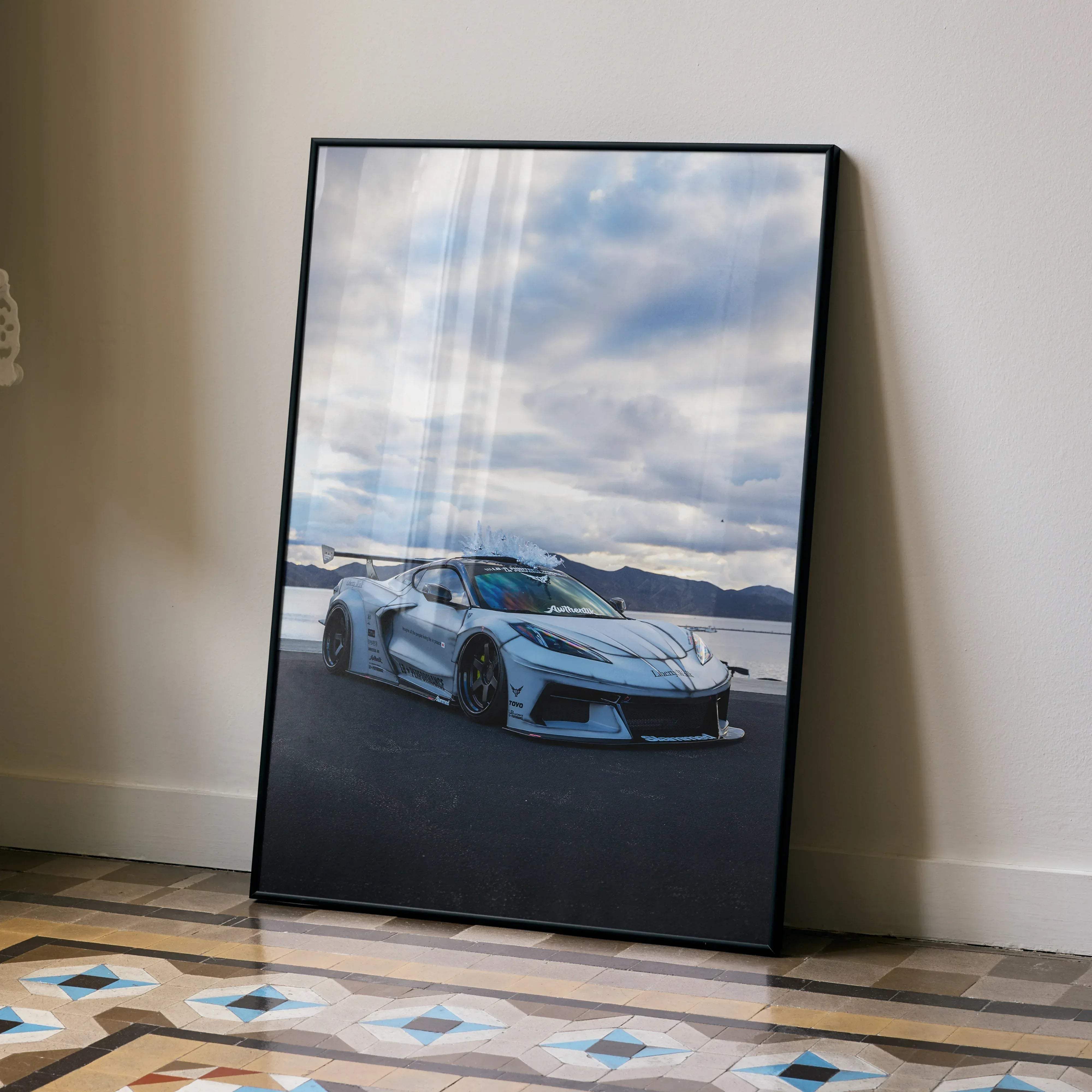 A high resolution premium satin poster of a light blue Chevrolet C8 Corvette with black rims near water