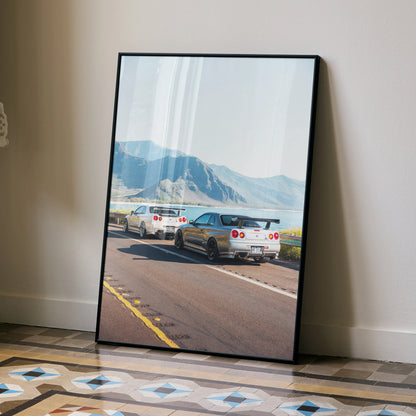 Nissan GT-R R34 Skyline on mountain road poster leaning against beige wall, automotive wall art.