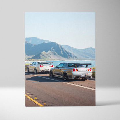 Vertical canvas art featuring two Nissan GTR R34 Skylines on an open road with mountains in the background.