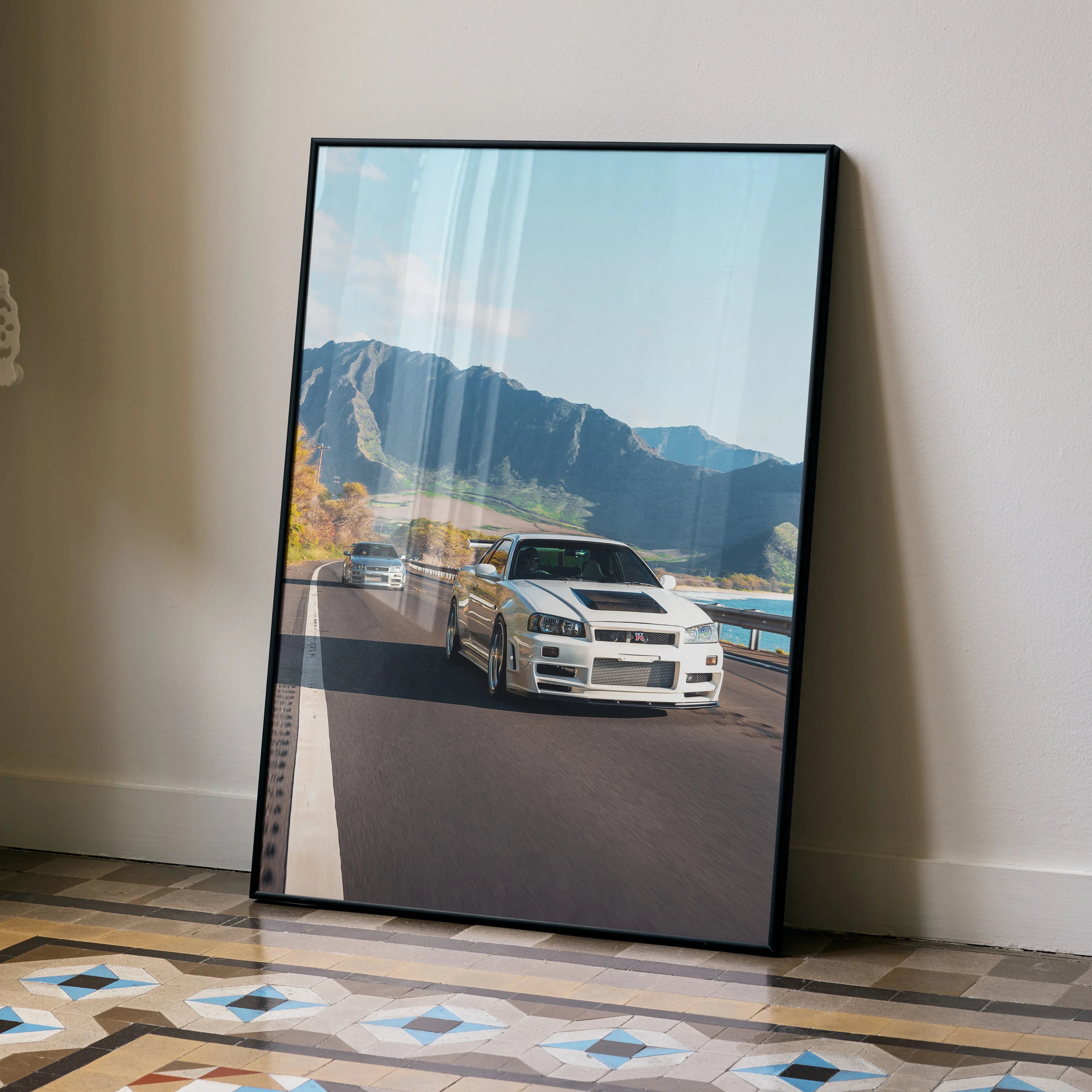 Nissan GT-R R34 Skyline poster wall art with mountain road and blue sky backdrop.