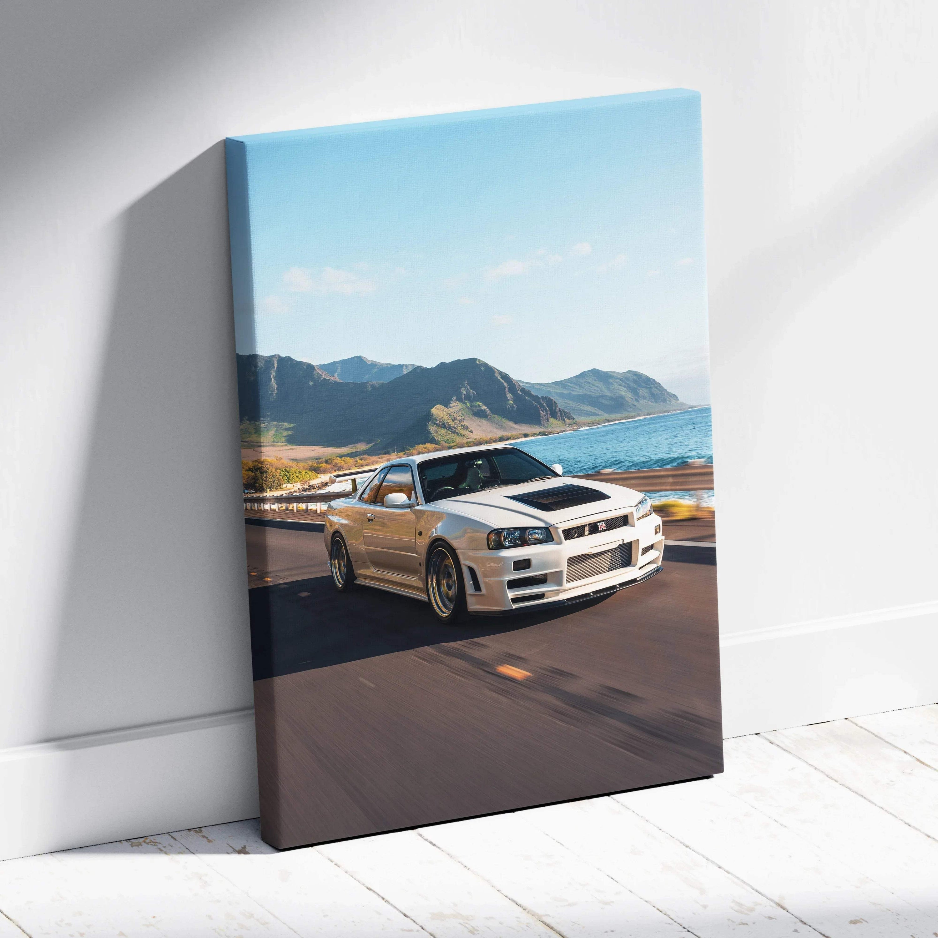 Nissan R34 GTR Skyline driving on coastal road canvas wall art with mountain background.