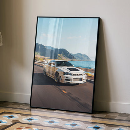 Nissan GT-R R34 Skyline poster leaning against wall with mountain and ocean background wall art.