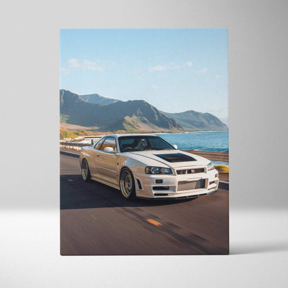 Vertical canvas art featuring a white Nissan R34 GTR Skyline driving along a coastal road with mountains and ocean backdrop.