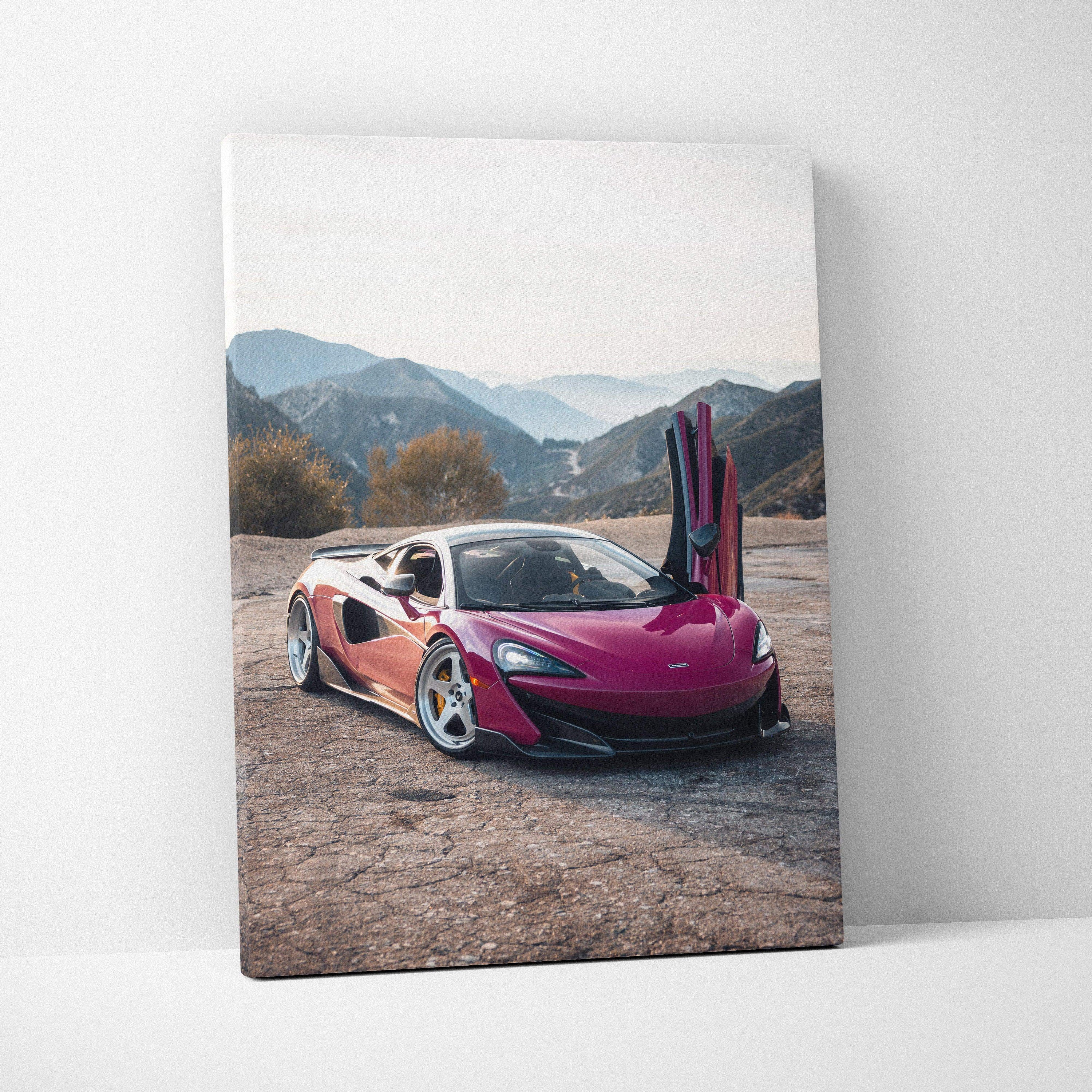 Vertical canvas wall art featuring a vibrant red McLaren 600LT with raised doors in a mountainous desert setting.