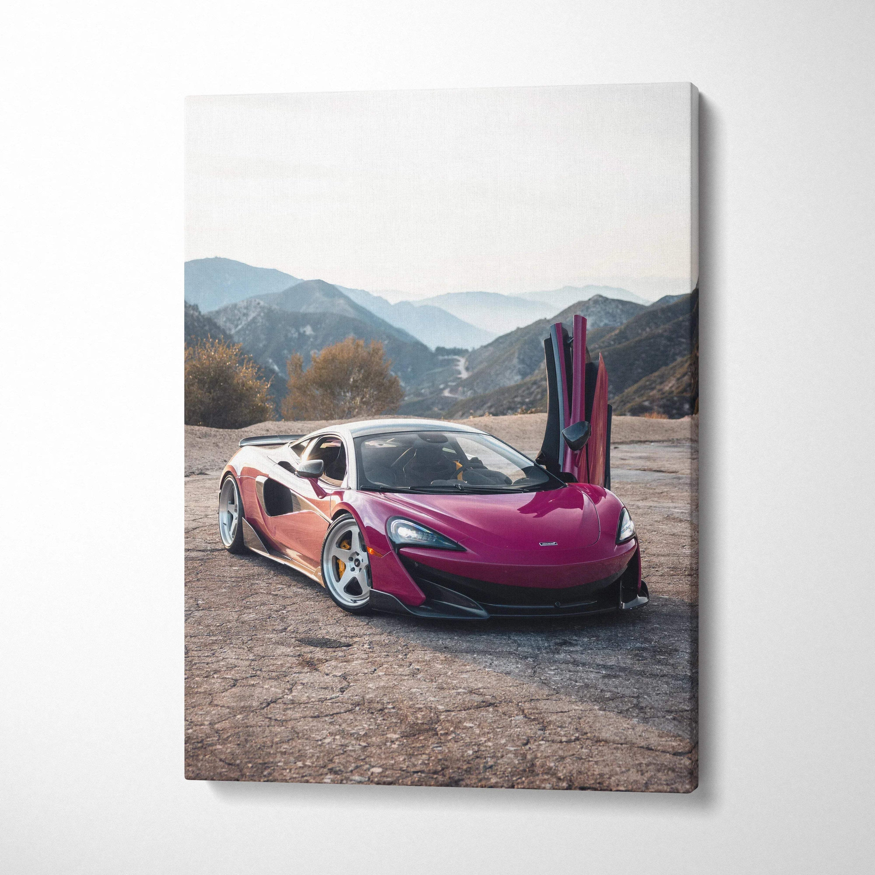 Pink McLaren 600LT with open vertical doors on mountain road canvas wall art.