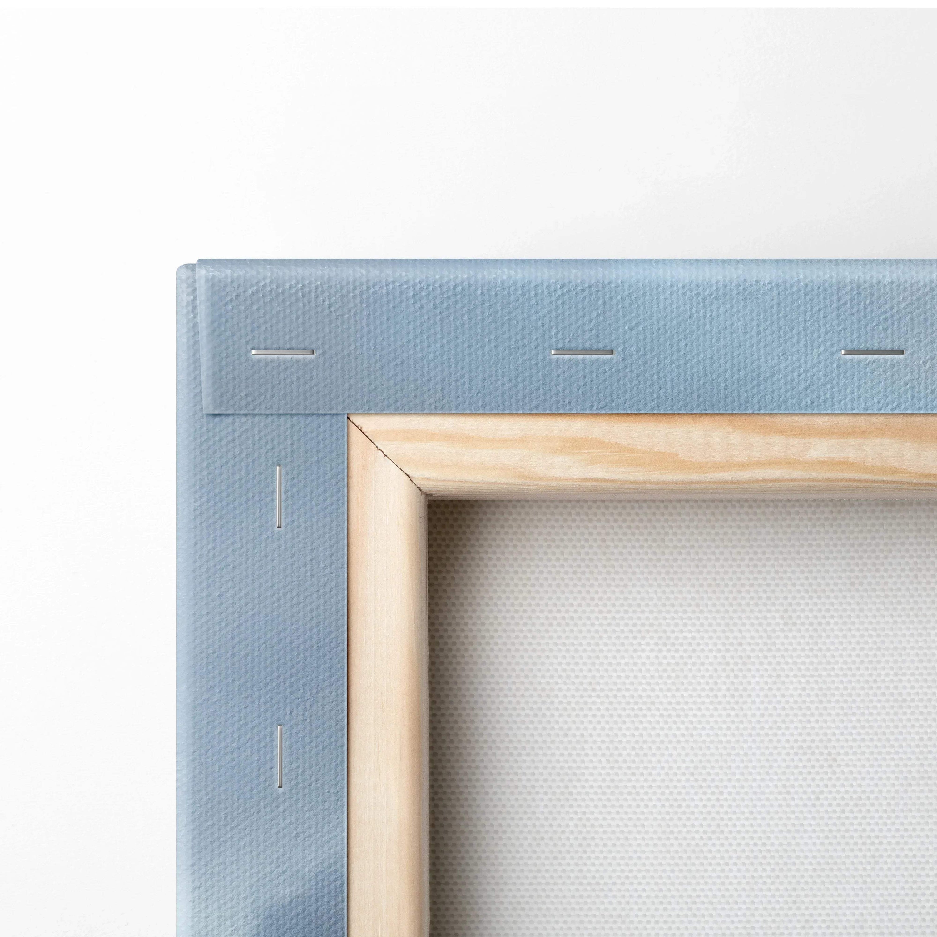 Corner close-up of stretched canvas wall art with light wood frame and blue fabric backing.