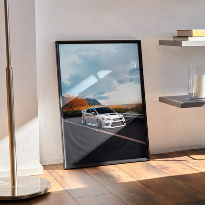 Slammed white Subaru WRX car poster with mountain and sky background, framed wall art on wooden floor.