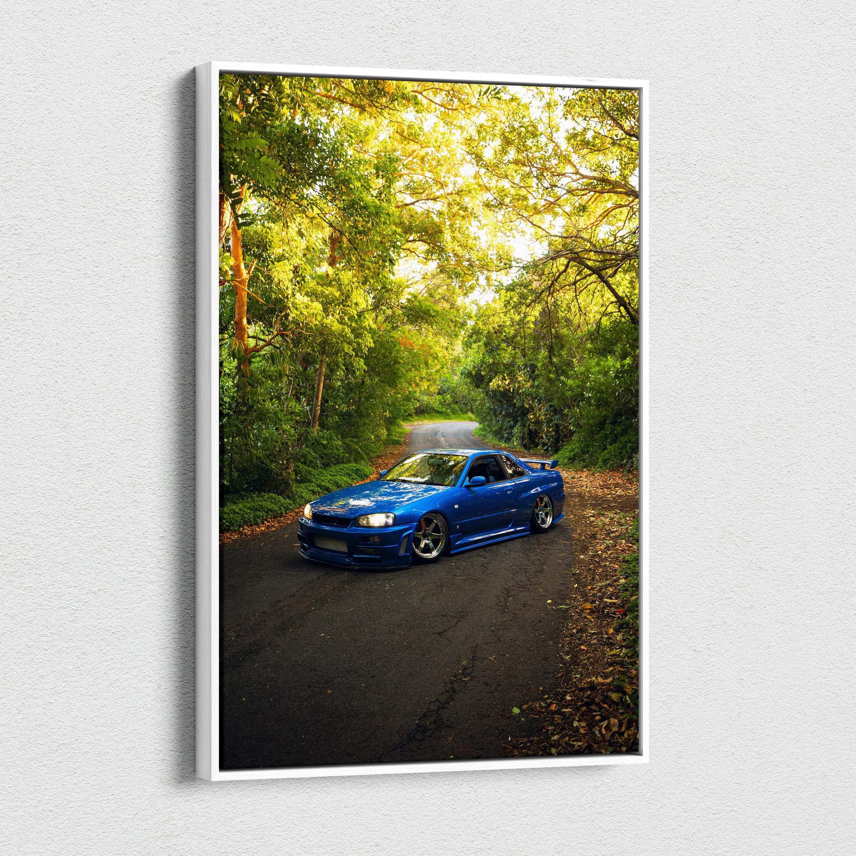 Blue Nissan GTR R34 Skyline on road surrounded by green trees canvas wall art vertical print.