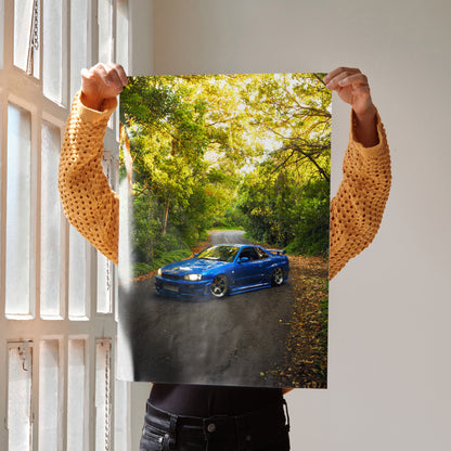 Nissan Skyline GTR R34 in blue on forest road poster wall art with sunlight filtering through trees.