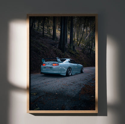 Toyota Supra Mk4 in dark forest setting poster wall art with sleek silver car and moody lighting.