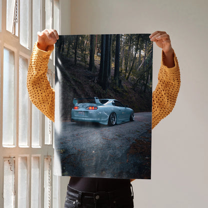 Toyota Supra Mk4 poster wall art featuring a silver car driving through a dark forest road at dusk.