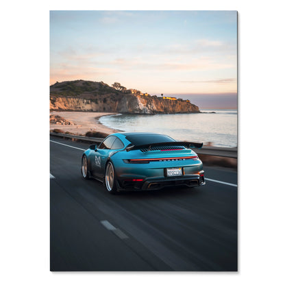 Porsche 911 driving along coastal road at sunset Poster Wall Art with scenic cliffs and ocean.