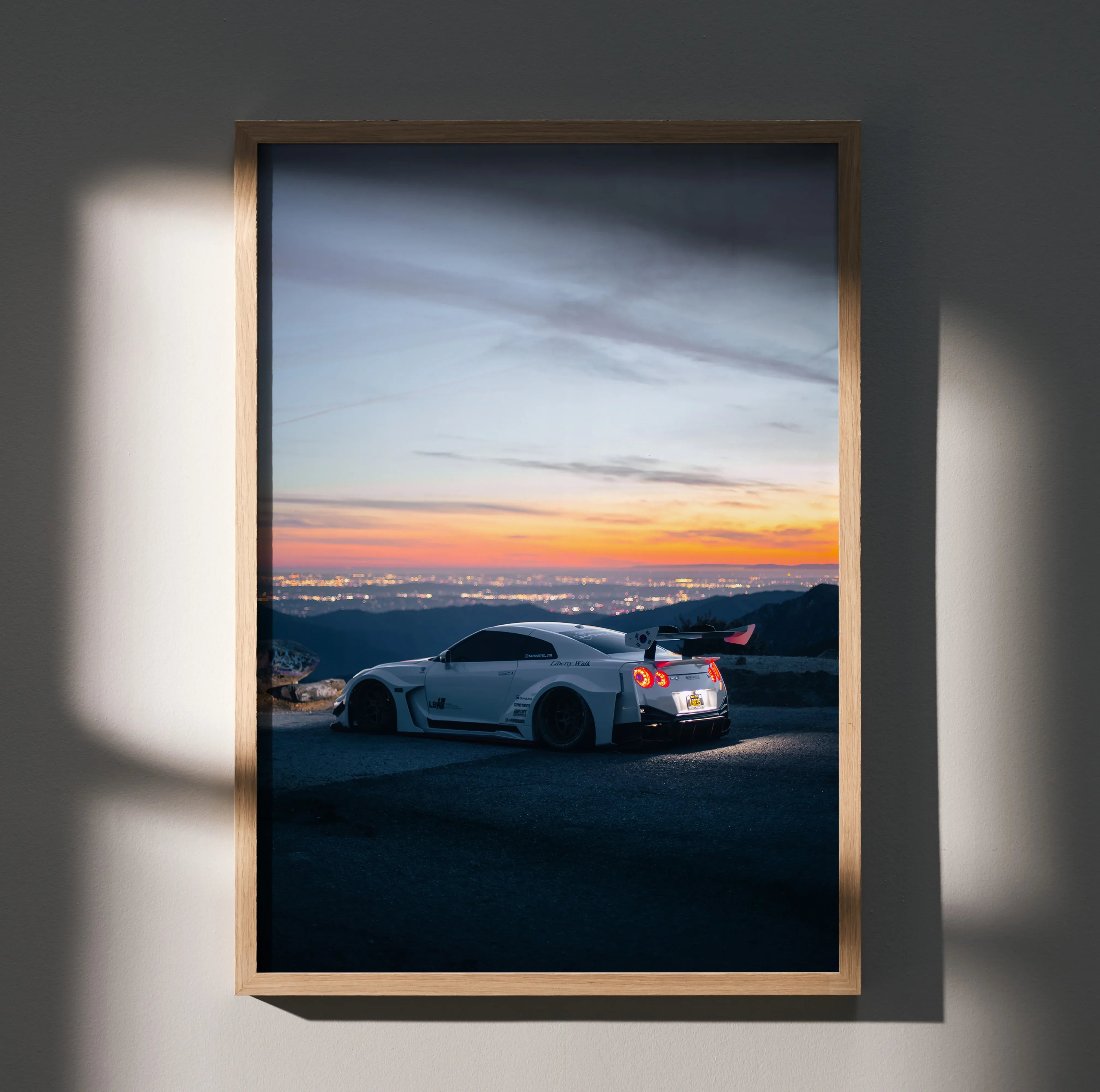 Nissan R35 GT-R poster wall art with sunset sky and coastal background in wooden frame.