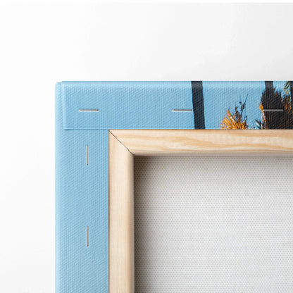 Close-up of natural wood frame and blue edge of stretched canvas wall art with visible staples and blank back.