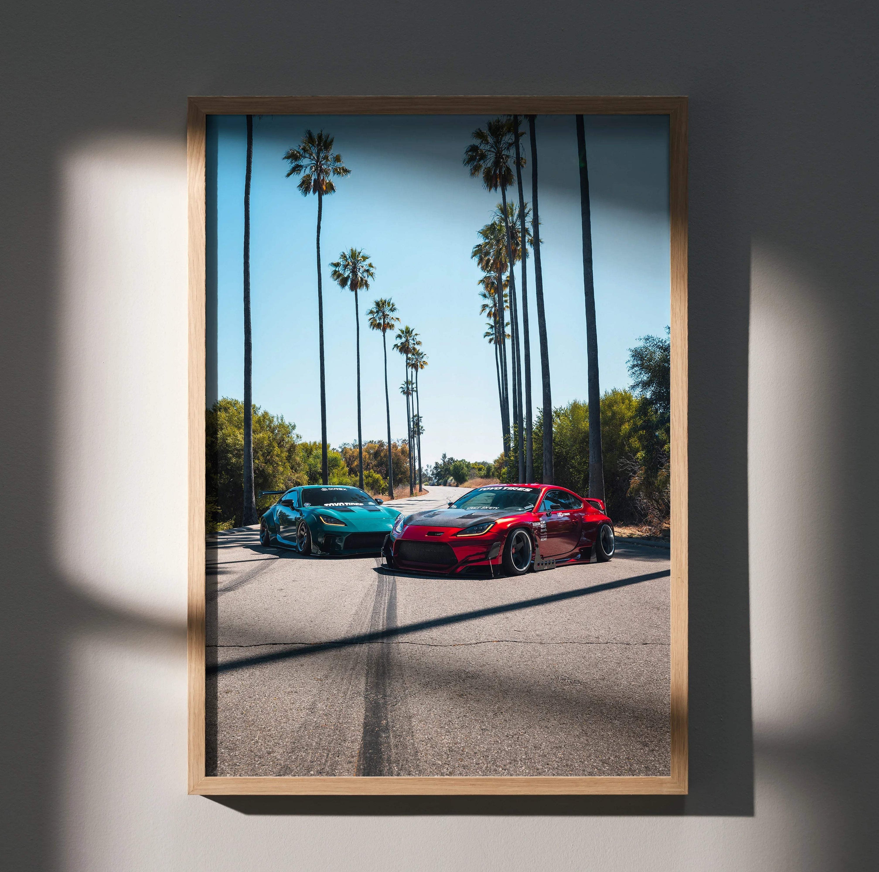 Toyota GR86 and FRS sports cars on sunlit street with tall palm trees poster wall art.