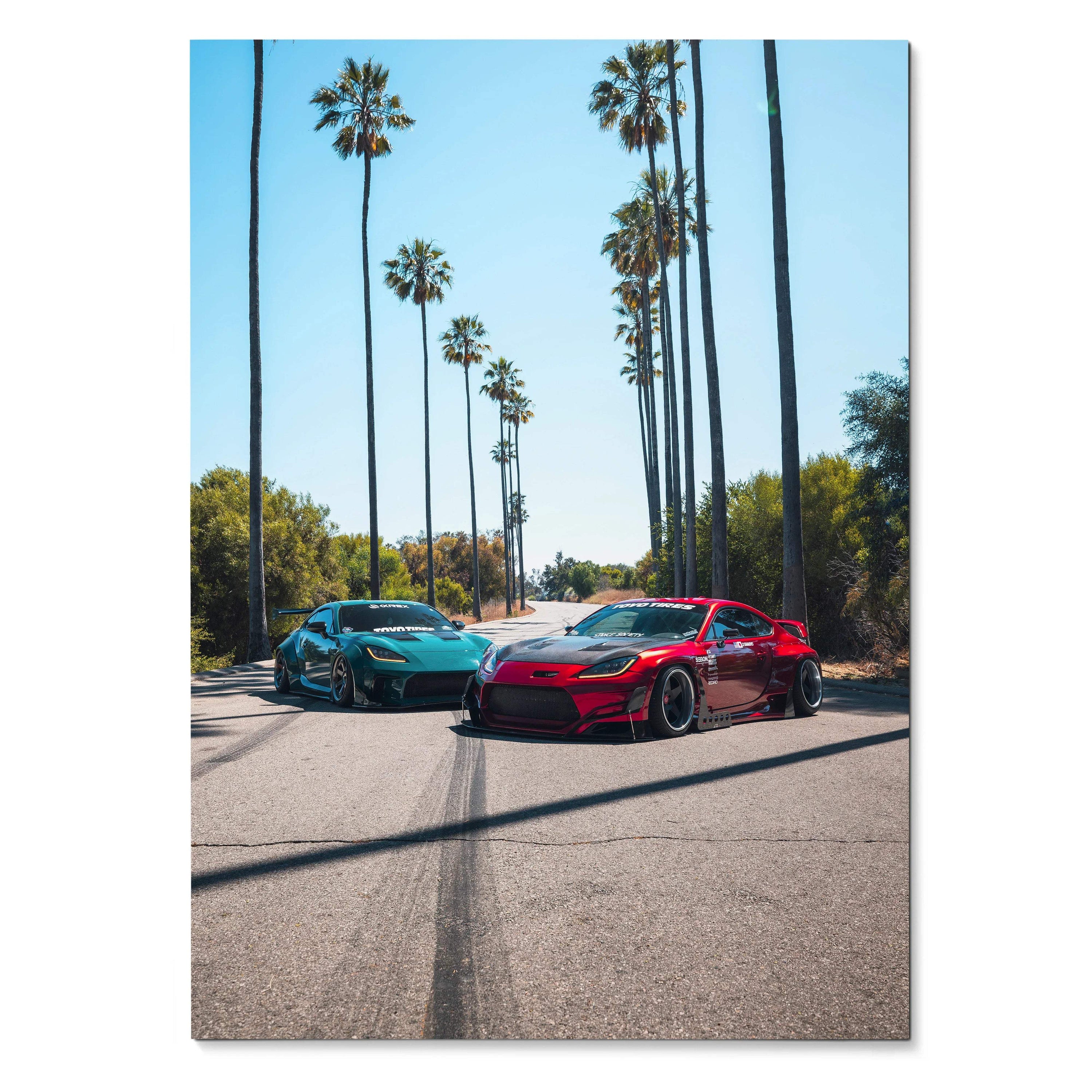Toyota GR86 and Subaru BRZ sports cars parked on sunlit street with tall palm trees poster wall art.