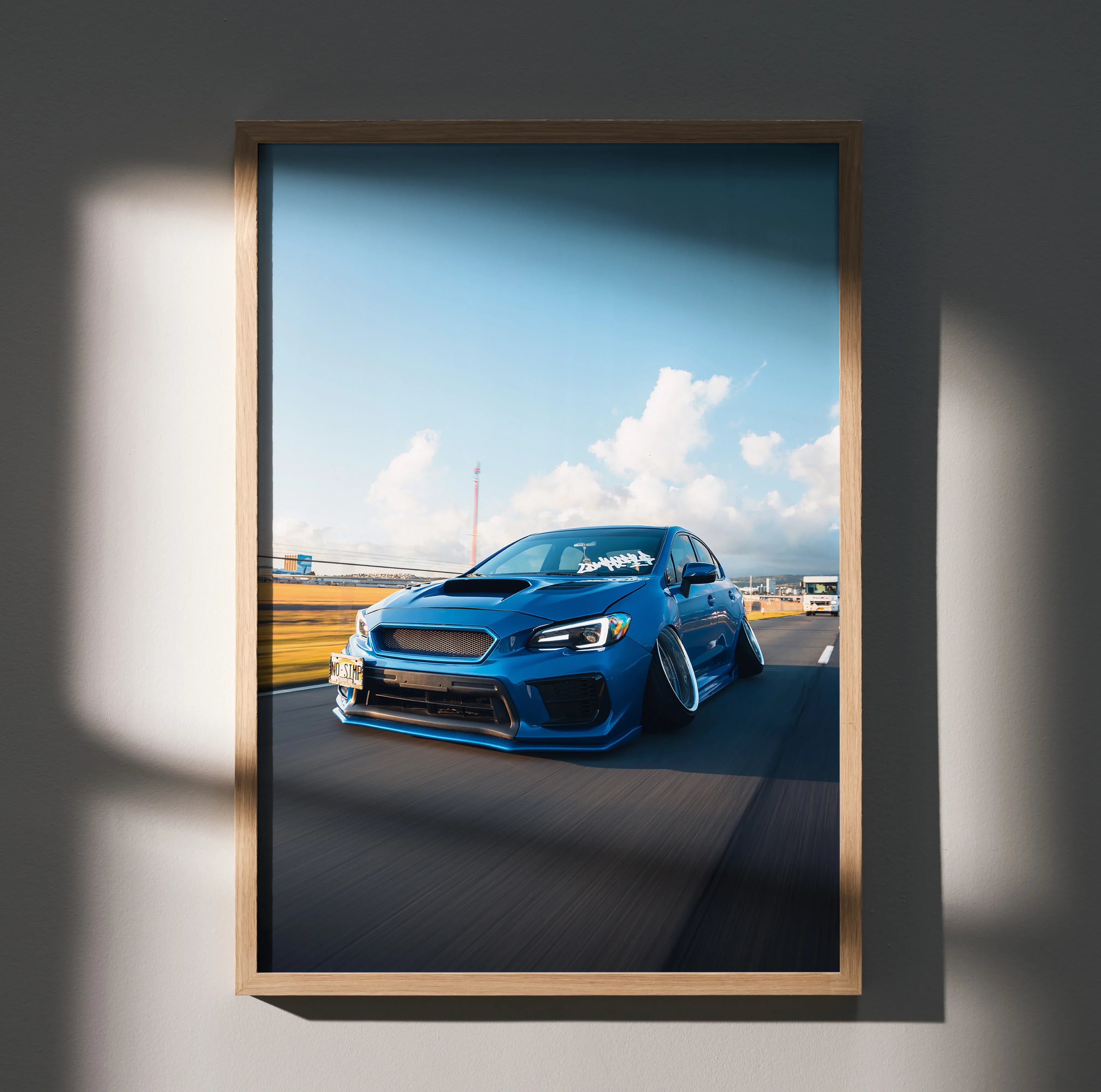 Blue slammed Subaru WRX poster with aggressive stance and clear blue sky wall art.