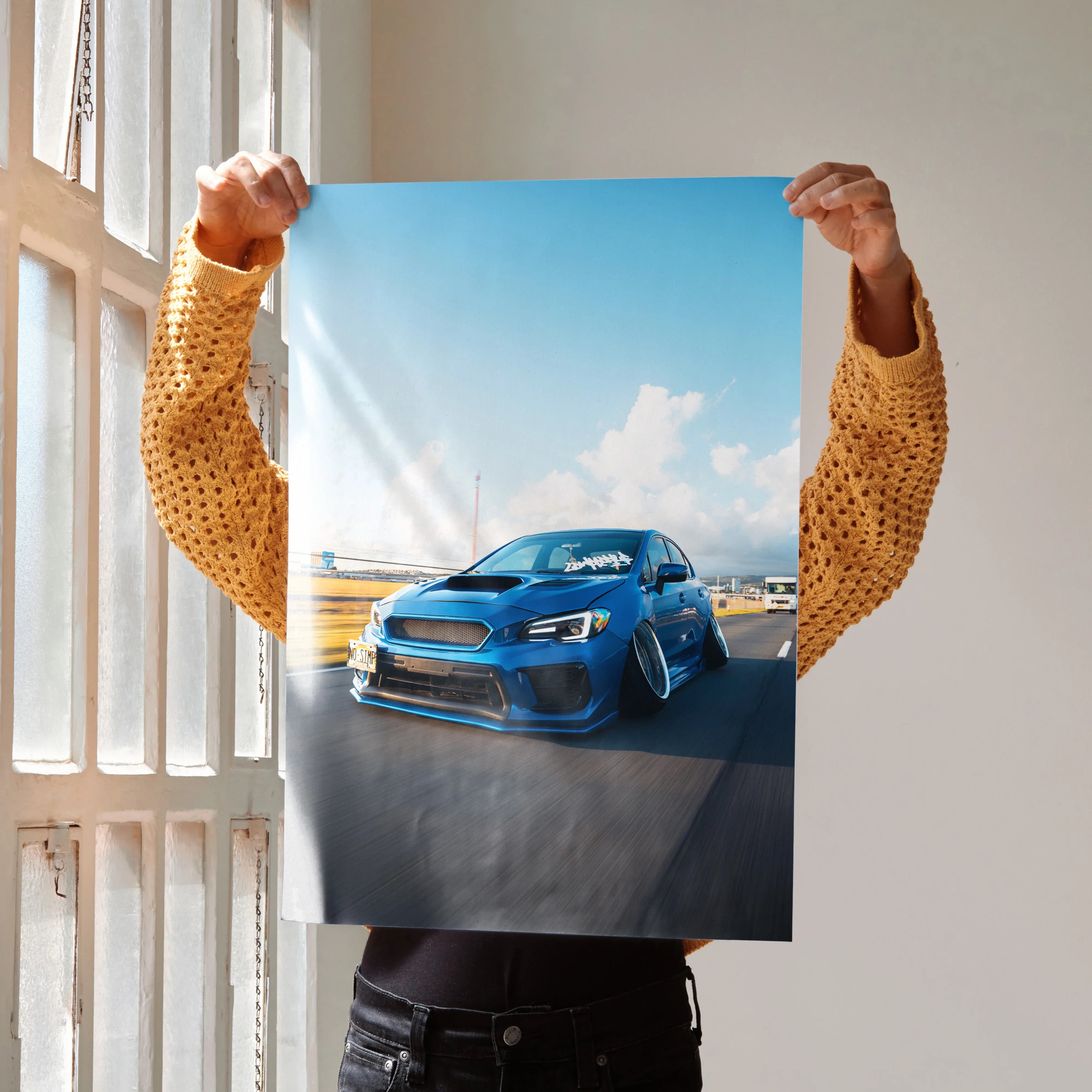 Slammed blue Subaru WRX parked on asphalt under clear sky poster wall art.