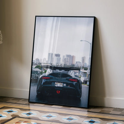 Toyota Supra Mk5 rear view on city road high-resolution poster wall art in black frame.