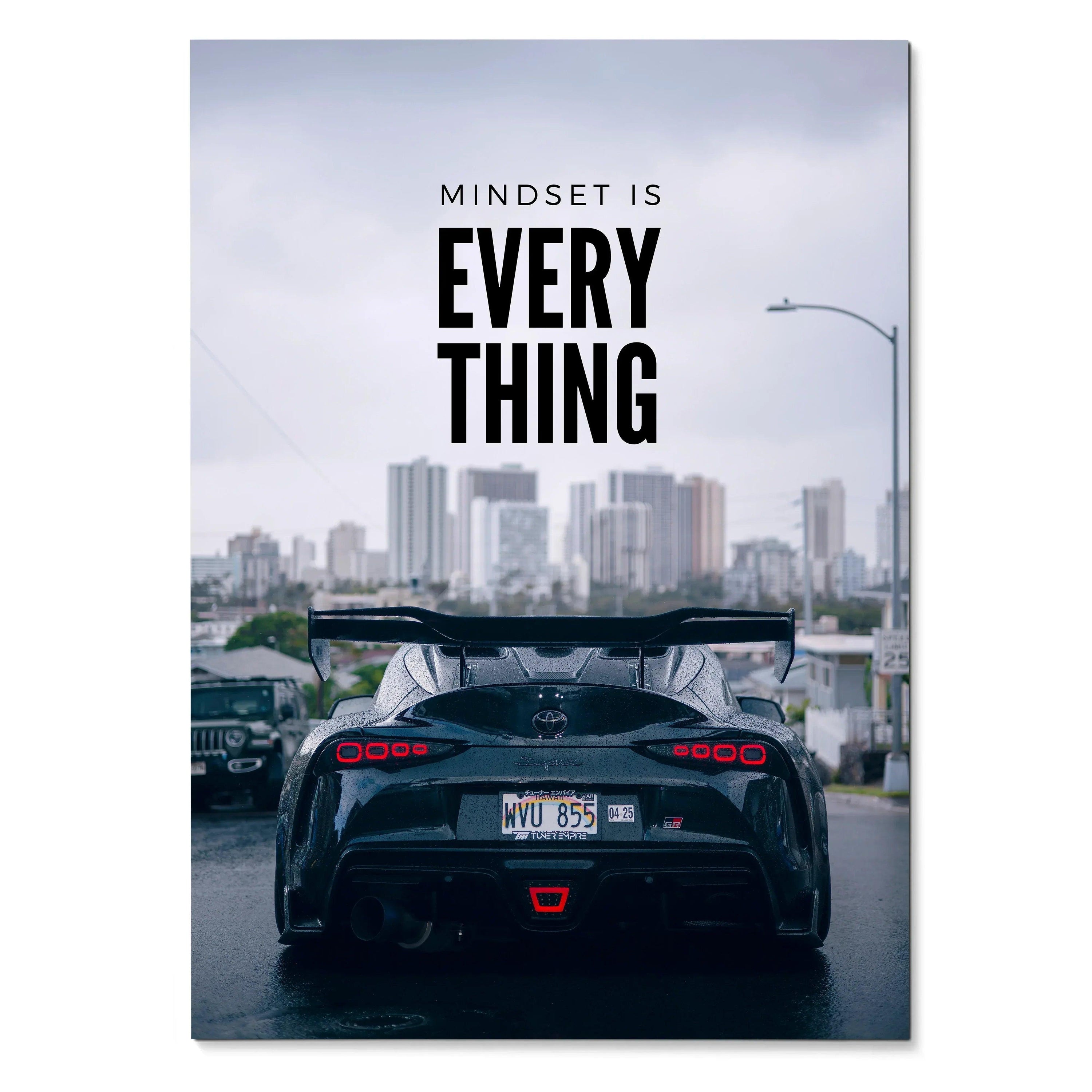 Poster wall art featuring a black Toyota Supra Mk5 rear with "Mindset is Everything" text against a city skyline background.