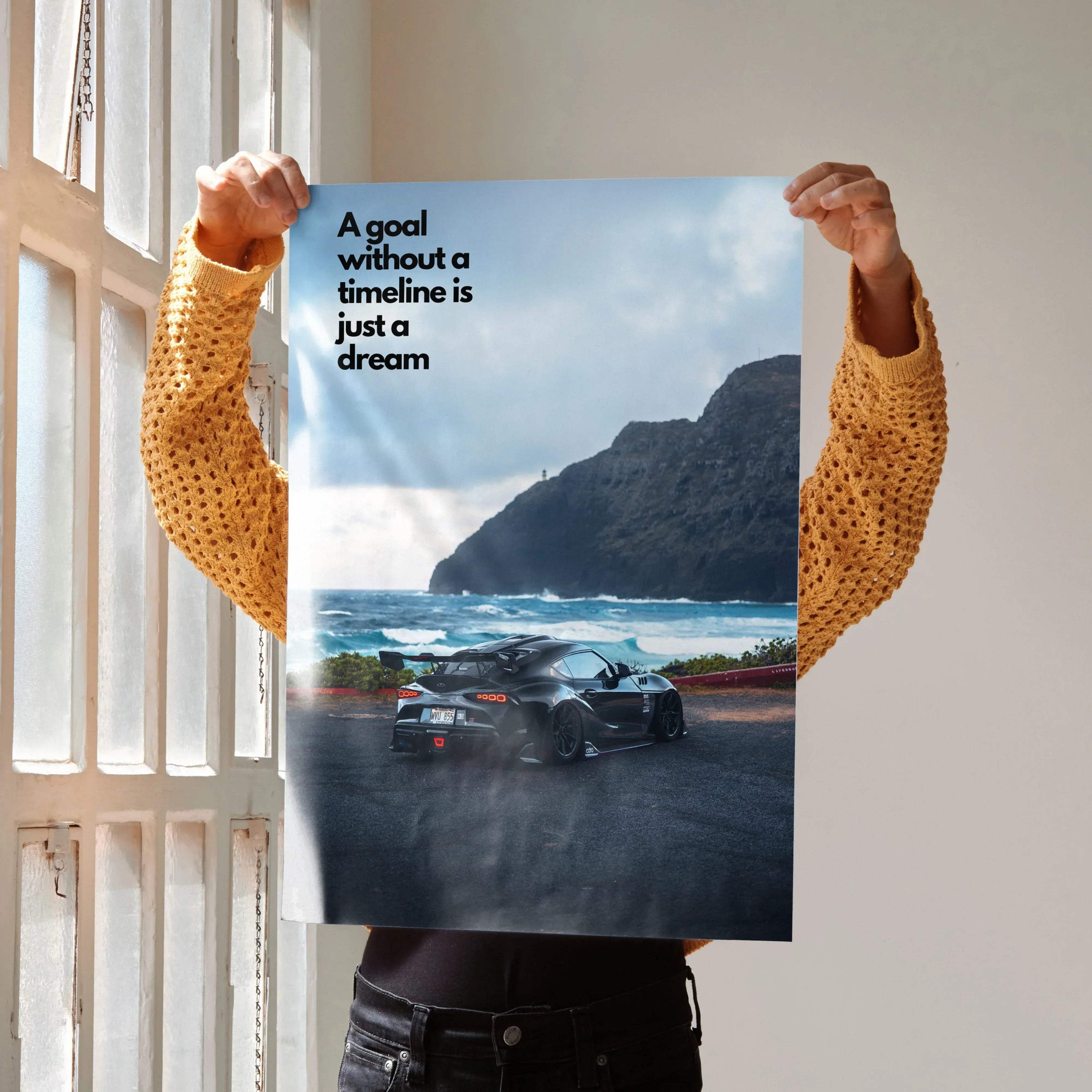 Motivational poster wall art featuring Toyota Supra Mk5 on coastal road with text "A goal without a timeline is just a dream".