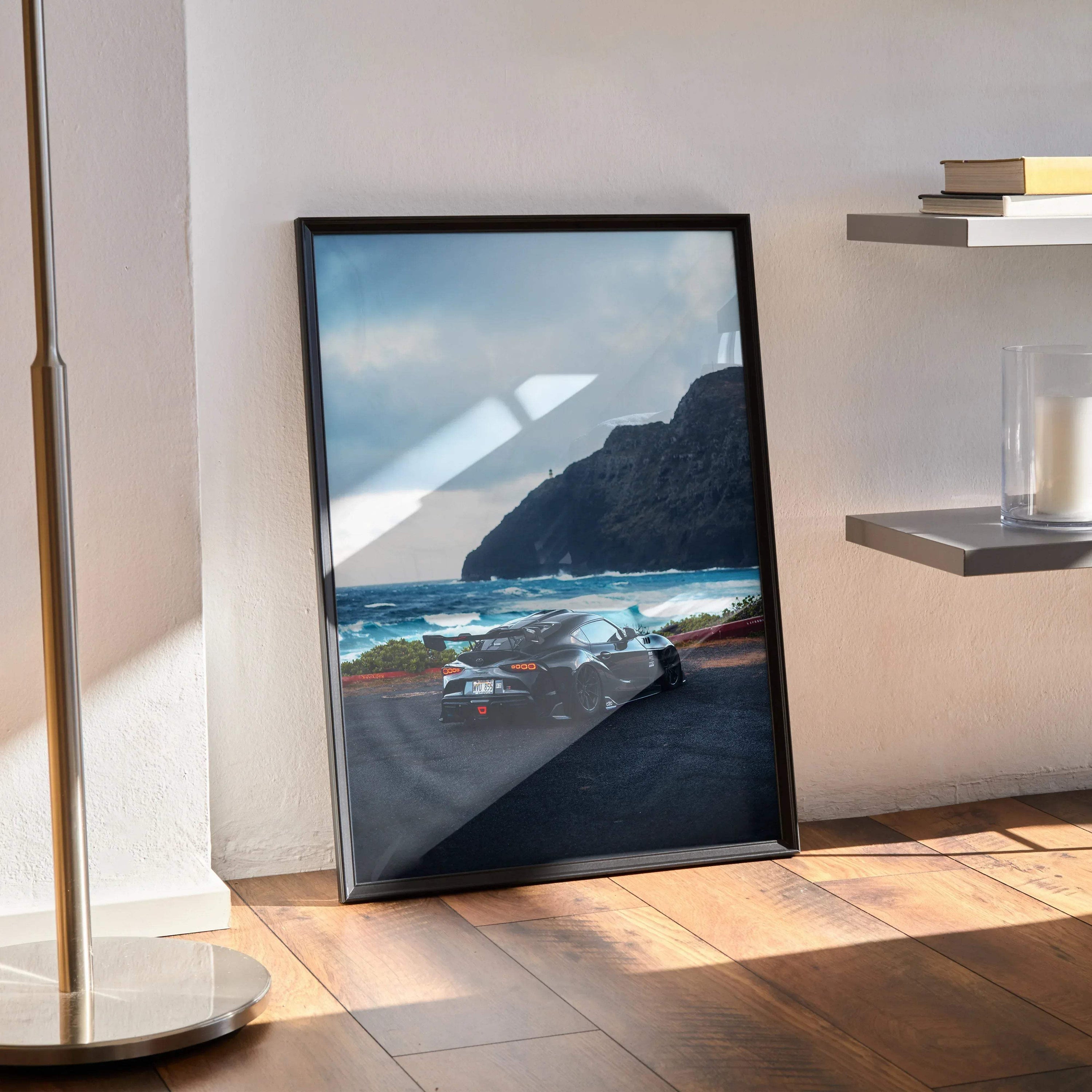 Toyota Supra Mk5 car poster leaning against wall with coastal cliff background wall art.