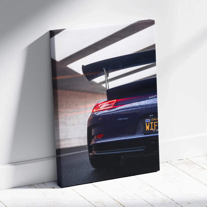 Vertical canvas art featuring rear view of black Porsche 911 GT3 RS with wing spoiler and license plate.