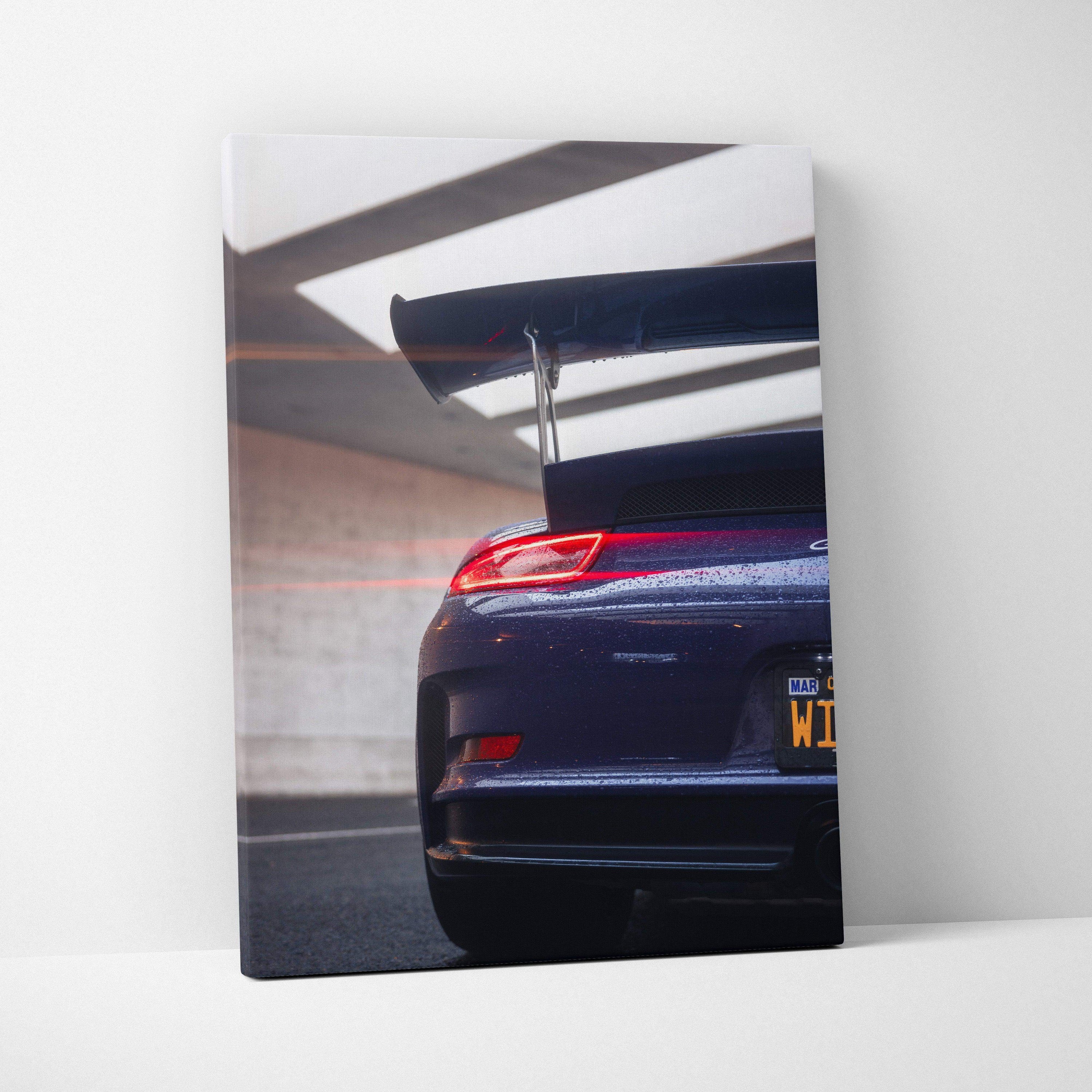 Vertical canvas art of dark blue Porsche 911 GT3 RS rear with spoiler in modern garage light.