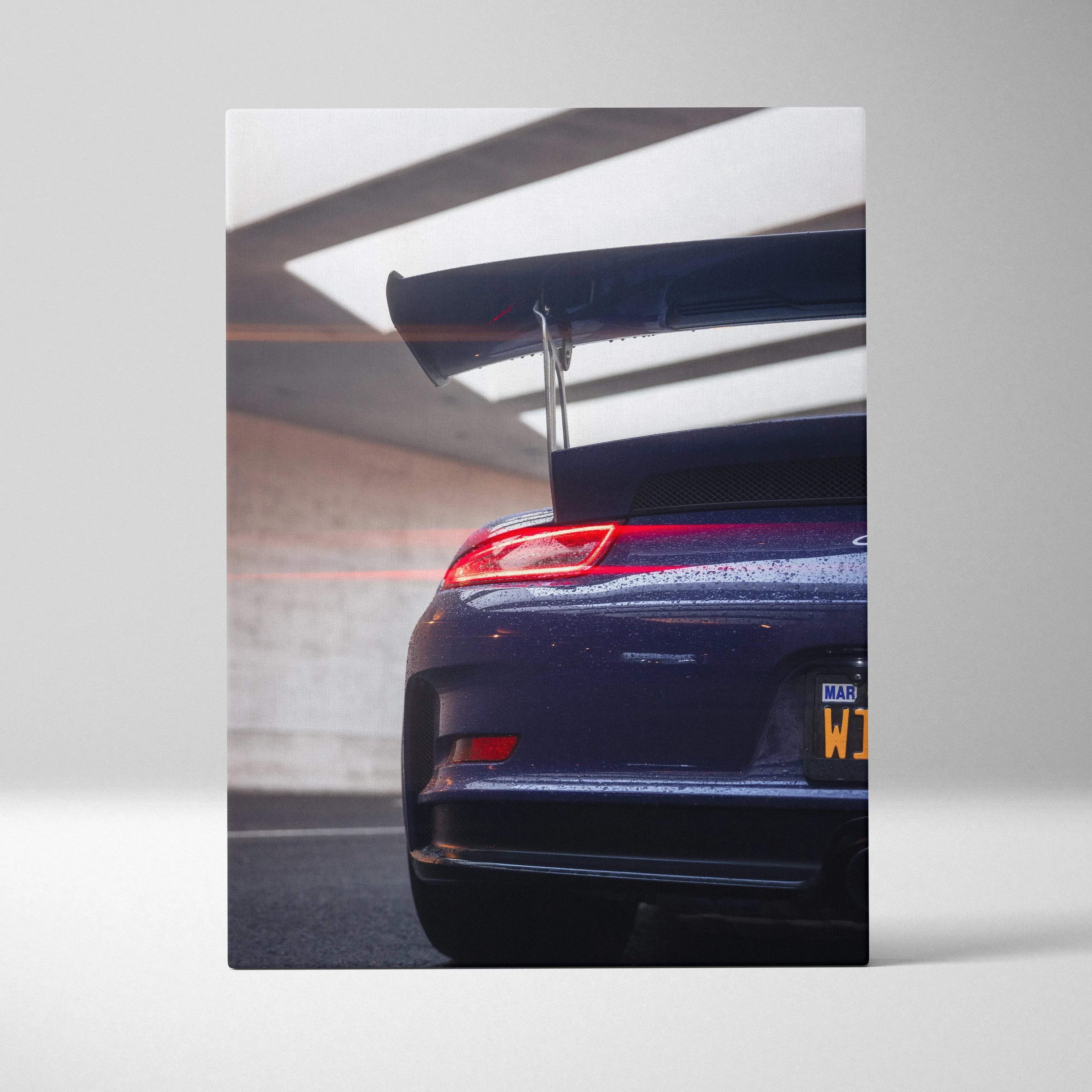 Vertical canvas wall art of Porsche 911 GT3 RS rear with large spoiler, glossy deep blue finish.