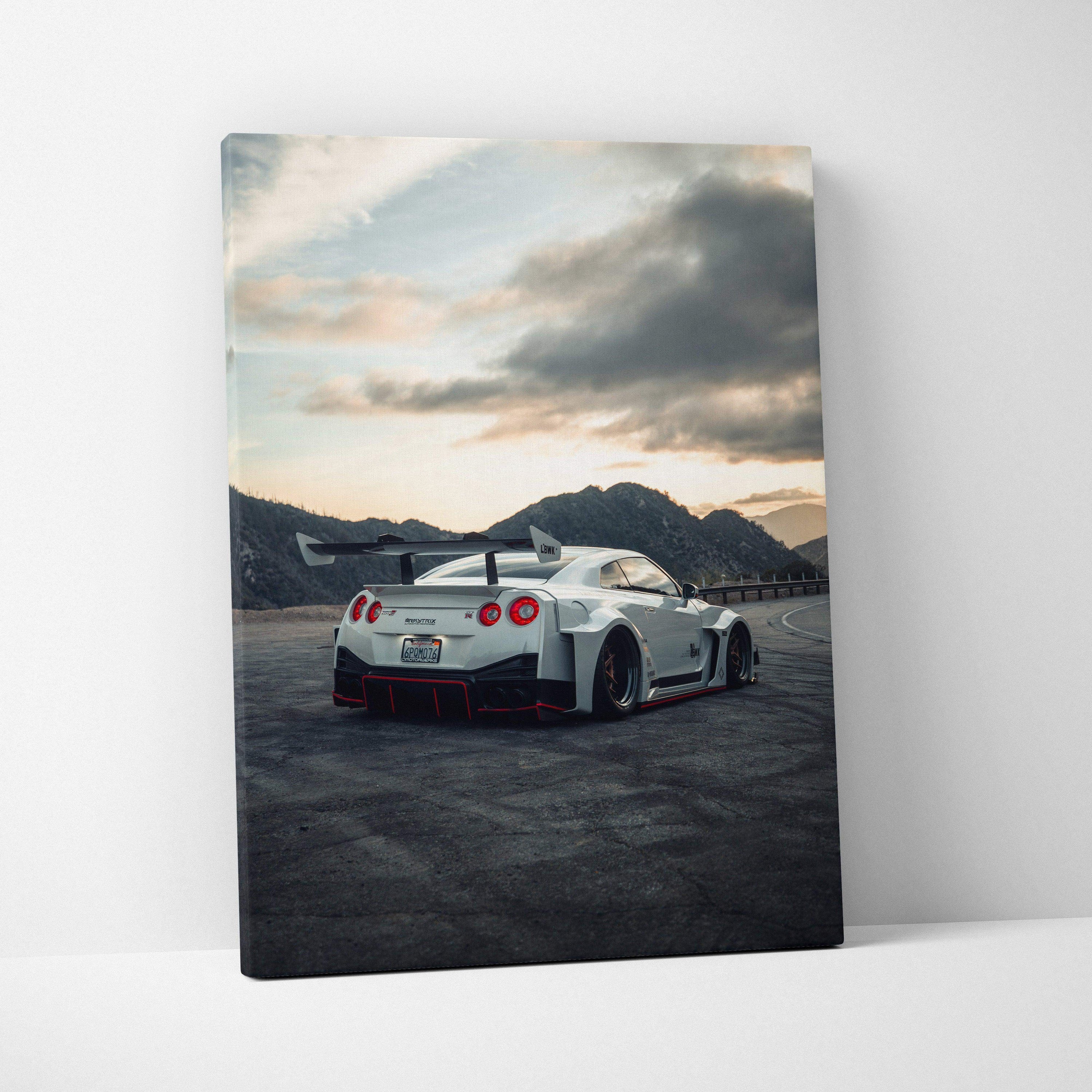 Vertical canvas art of a white Nissan R35 GTR with spoiler on mountain road under cloudy sky wall art.