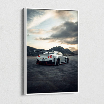 Vertical Nissan R35 GTR canvas art showing a white sports car on asphalt with mountains and cloudy sky background.