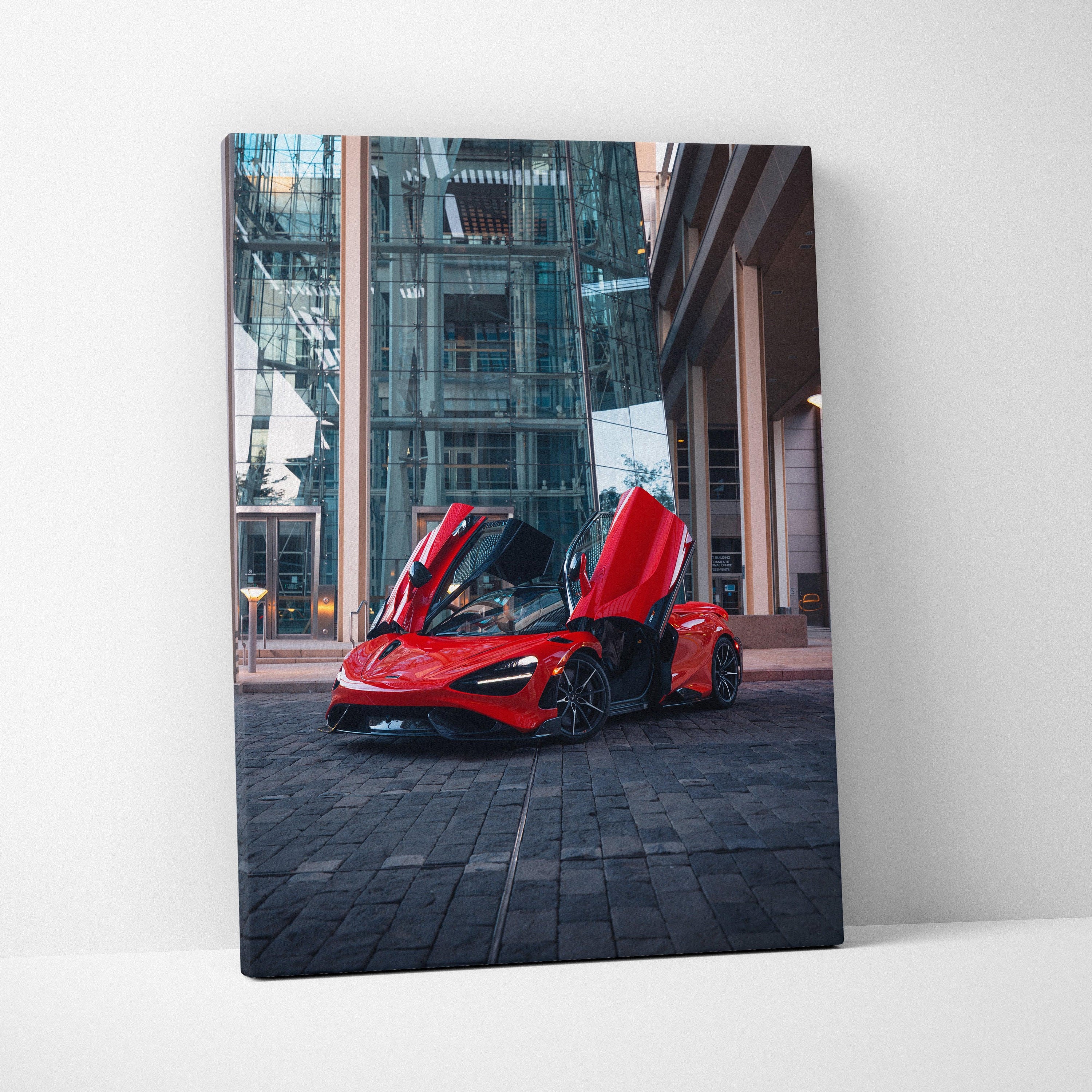 Red McLaren 765LT with doors open against urban glass building backdrop, vertical canvas wall art.