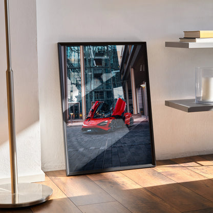 McLaren 765LT supercar with open doors in urban setting, vibrant red poster wall art in black frame.