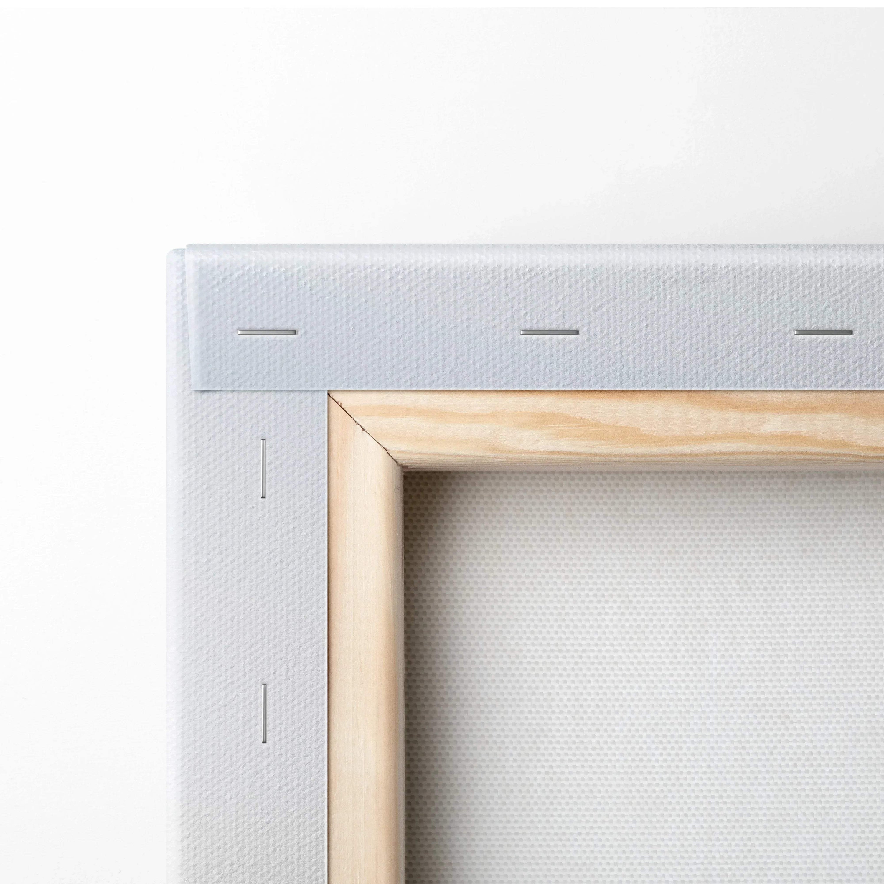 Close-up of white stretched canvas wall art with wooden frame and visible staples.