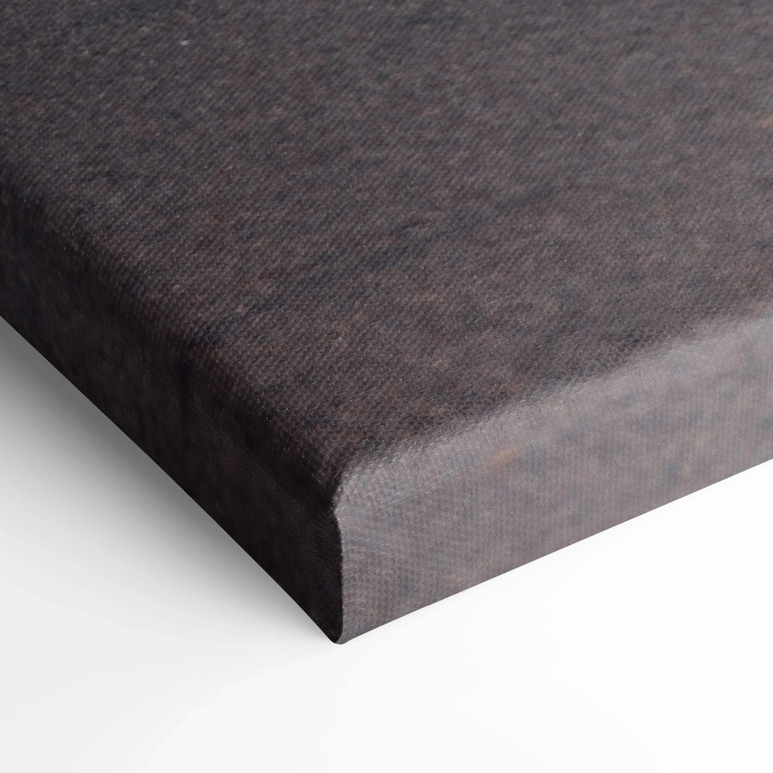 Close-up of black wrapped edge on vertical canvas wall art with fine texture.