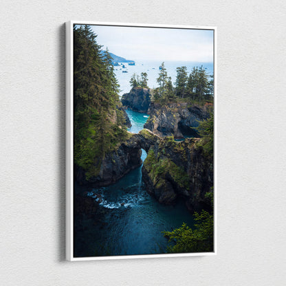 Rugged coastal cliffs with natural rock arch over emerald water and evergreen trees canvas art