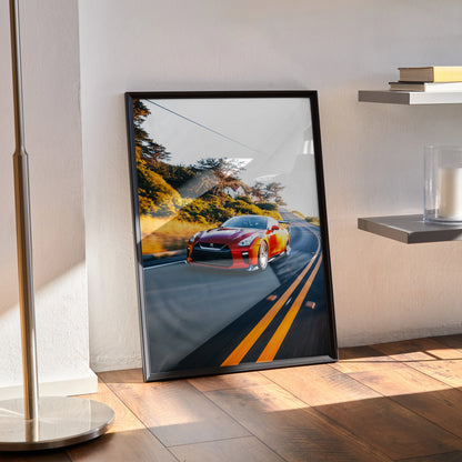 Nissan R35 GTR poster with vibrant car on scenic road, framed wall art leaning on floor.