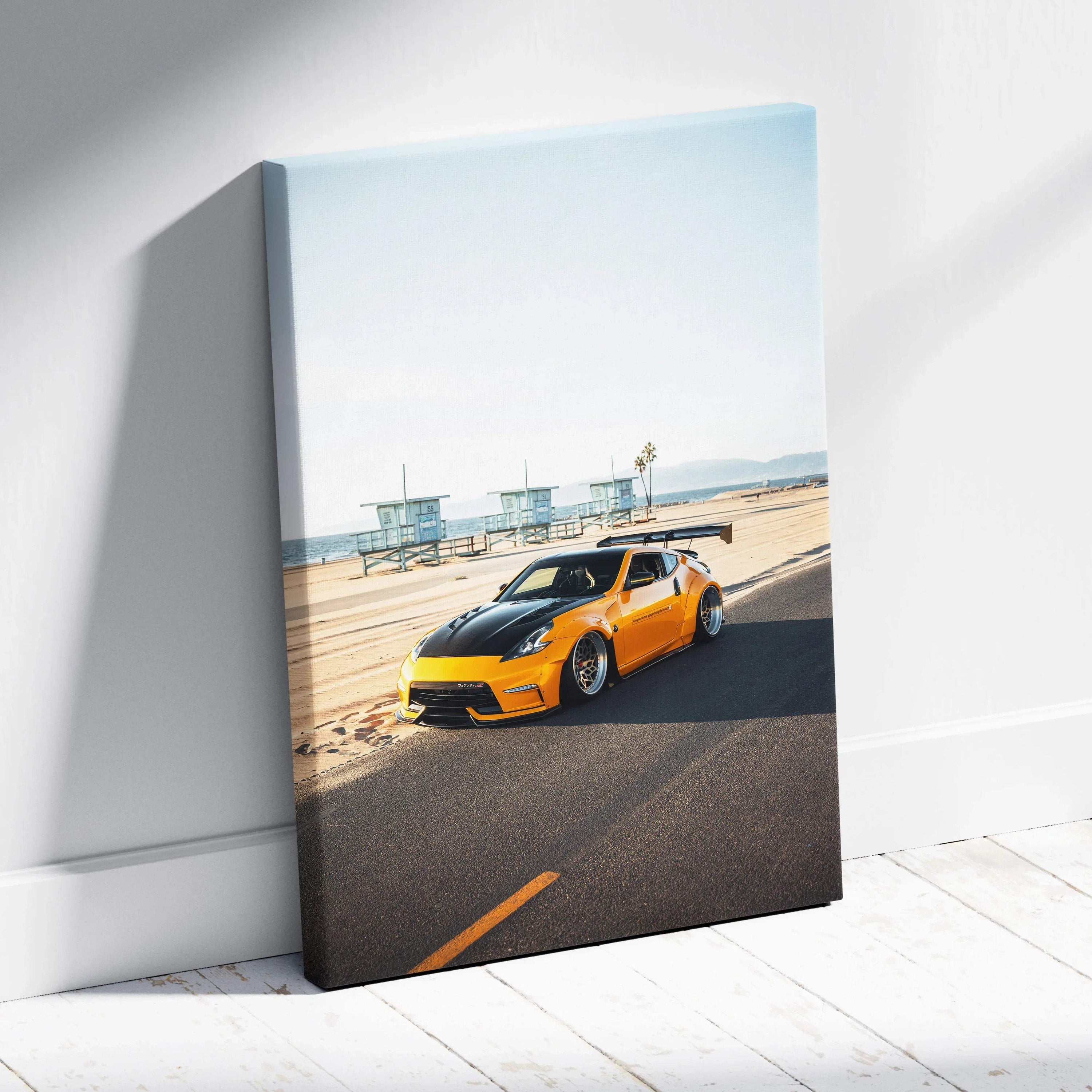 Vertical canvas wall art featuring a bright orange Nissan 370z on a sunny coastal road with a clear sky.